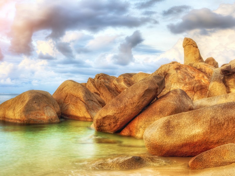 The Rock from Thai island of Koh Samui. The picturesque pile of rocks on the beach, illuminated by the sunrise